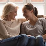 Une femme mature et sa fille souriante discute de l'assurance vie et succession