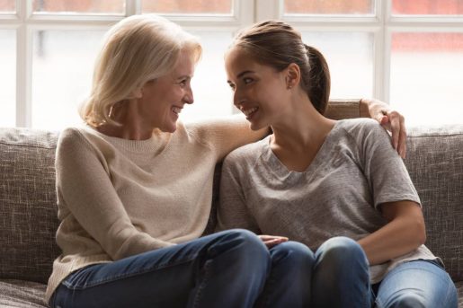 Une femme mature et sa fille souriante discute de l'assurance vie et succession